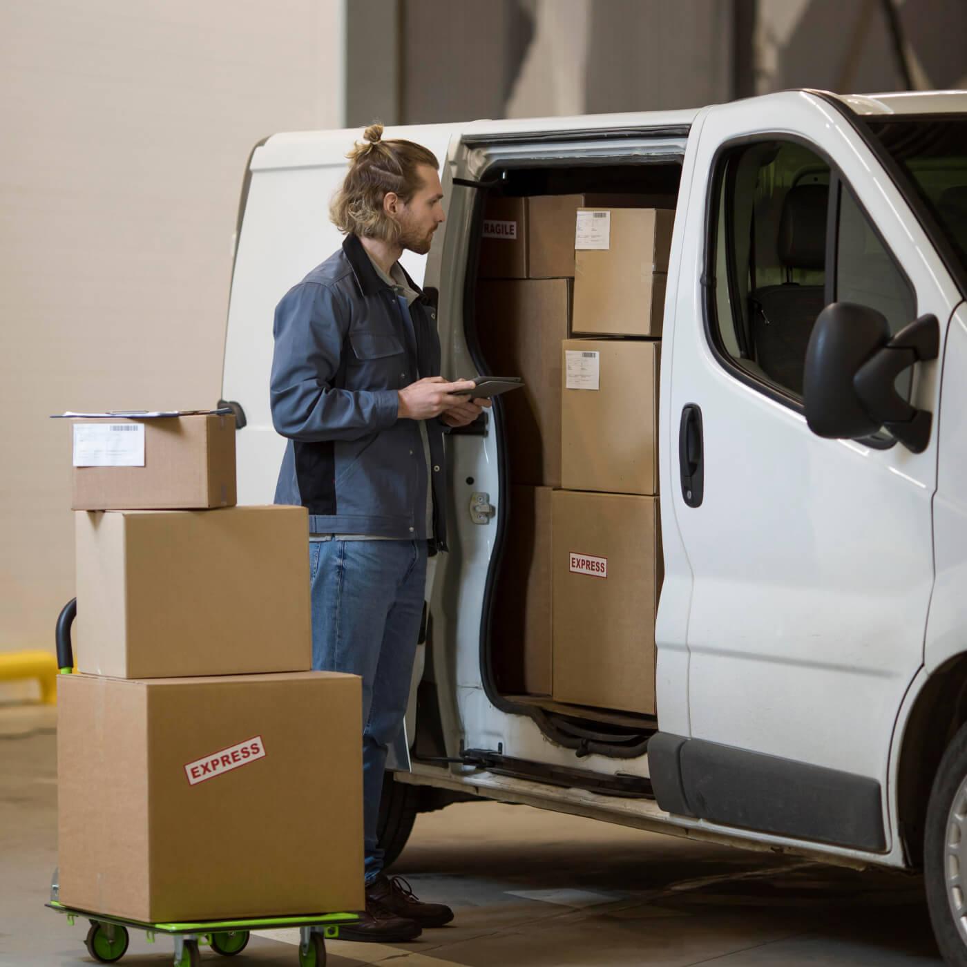 Repartidor revisando la mercadería a entregar a partir de una estrategia de cross docking, en la que retira paquetería en un depósito